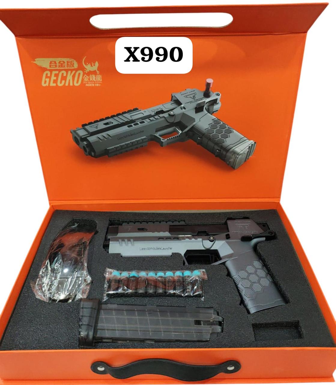 A toy gun labeled X990 GECKO GUN displayed in an orange case with Ammunition and other accessories.