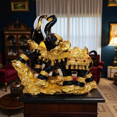 Decorative black and gold elephant sculpture on a wooden platform in an elegant room.