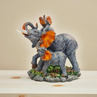 Decorative figurine of two elephants with orange trunks on a beige background