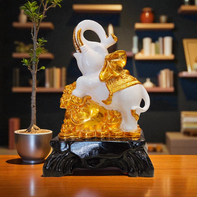 Decorative elephant sculpture with gold accents on a wooden table