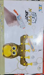 Packaging for a toy resembling an owl with a gun, predominantly yellow and brown with a white background, including a real gun and a remote control.
