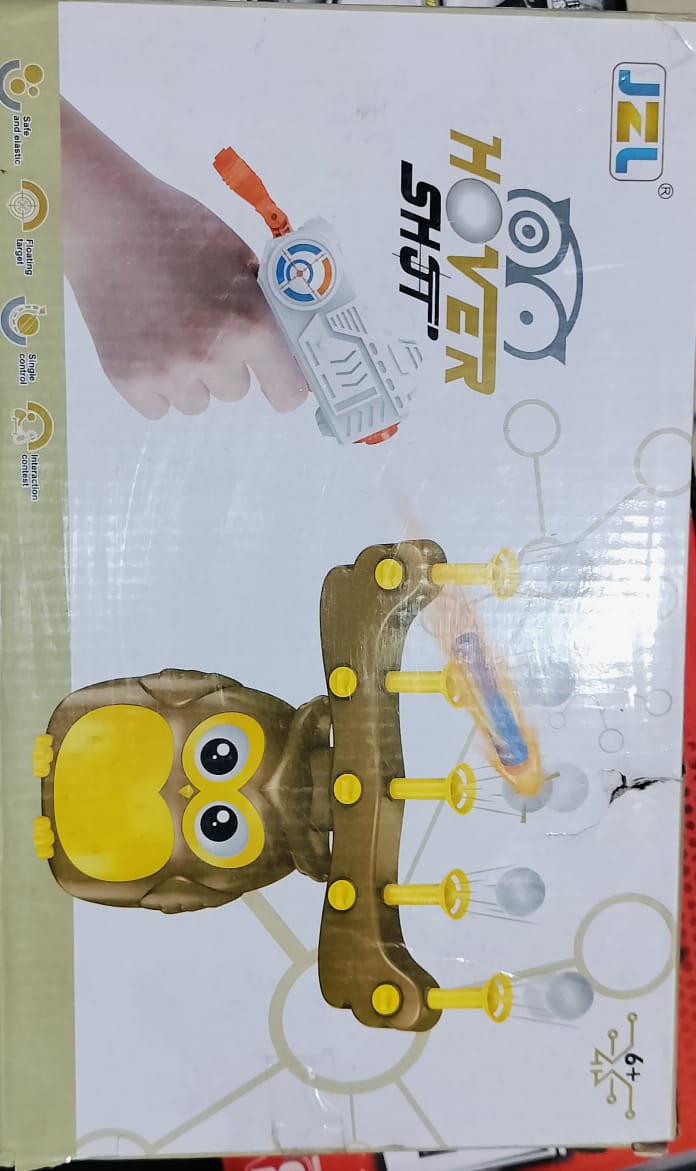 Packaging for a toy resembling an owl with a gun, predominantly yellow and brown with a white background, including a real gun and a remote control.