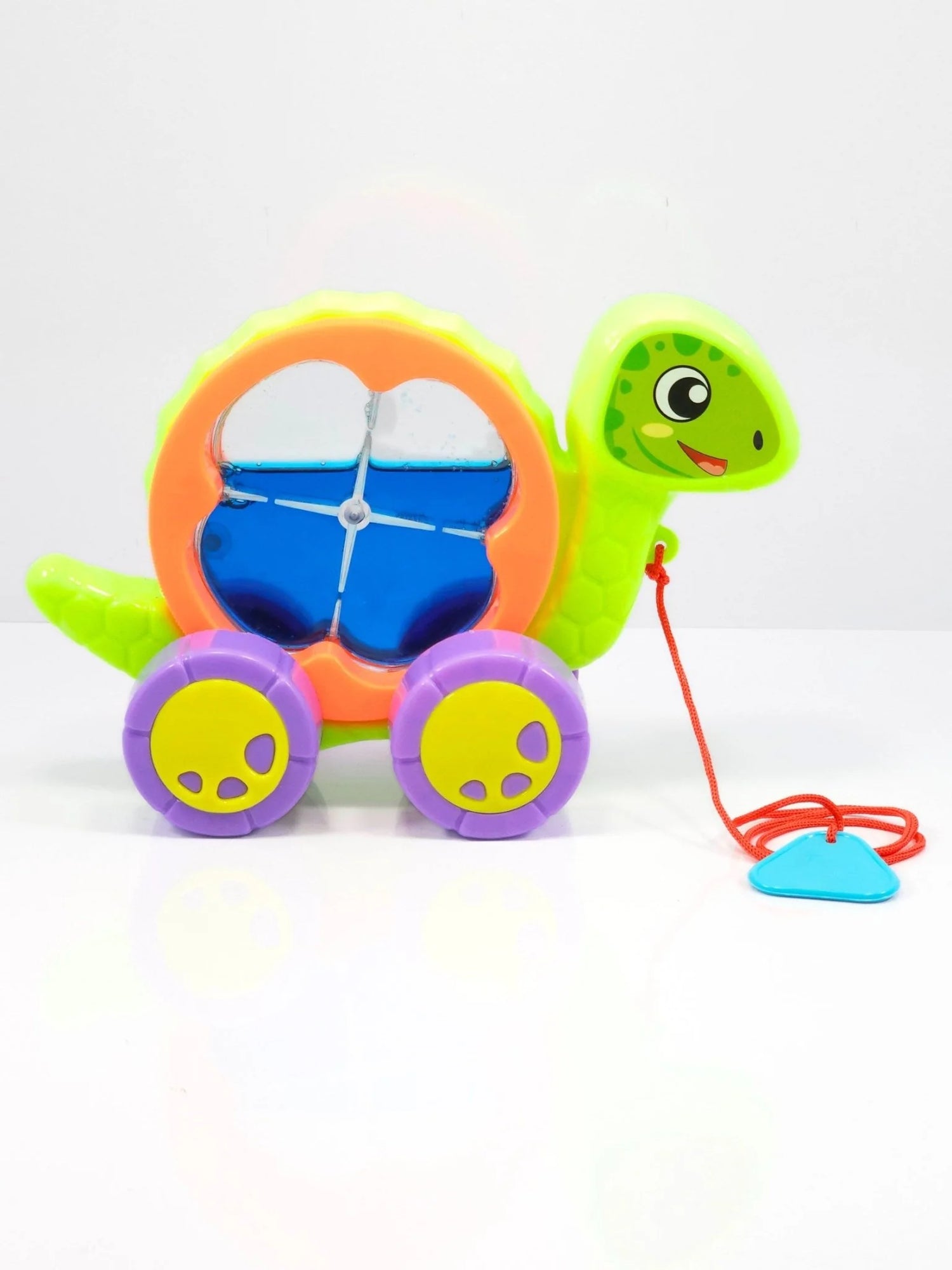 Colorful toy turtle with wheels and a pull string on a white background