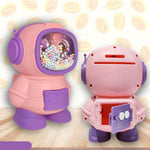 Pink and purple robot toy with a ball pit on a light wooden surface.