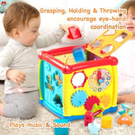 Child playing with a colorful educational toy cube on a carpeted floor.