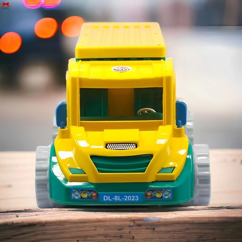 Toy dump truck on a wooden surface with blurred lights in the background