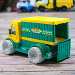 Toy truck with a green container and yellow top on a wooden surface