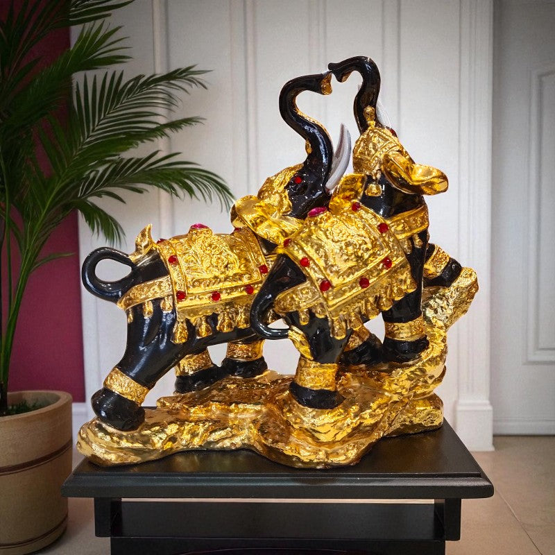 Decorative gold and black elephant statue on a stand with a plant in the background.