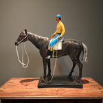 Front view of black horse with yellow-blue rider showpiece