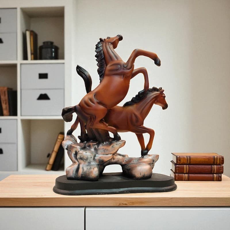 Statue of two horses on a rock with books in the background