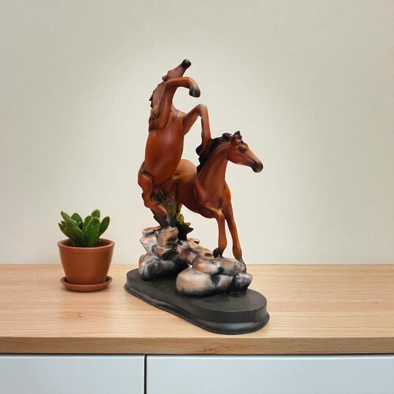 Wooden horse sculpture on a wooden surface with a potted plant