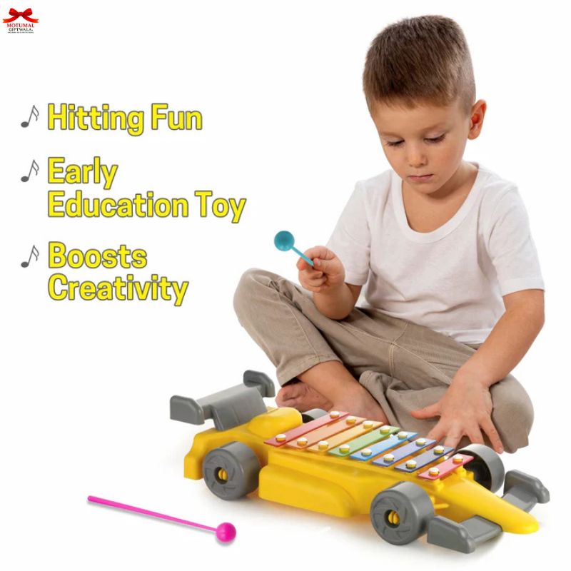 Child playing with a colorful toy xylophone shaped like a car on a white background