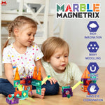 Two children playing with colorful marble magnetrix toys on a wooden floor.