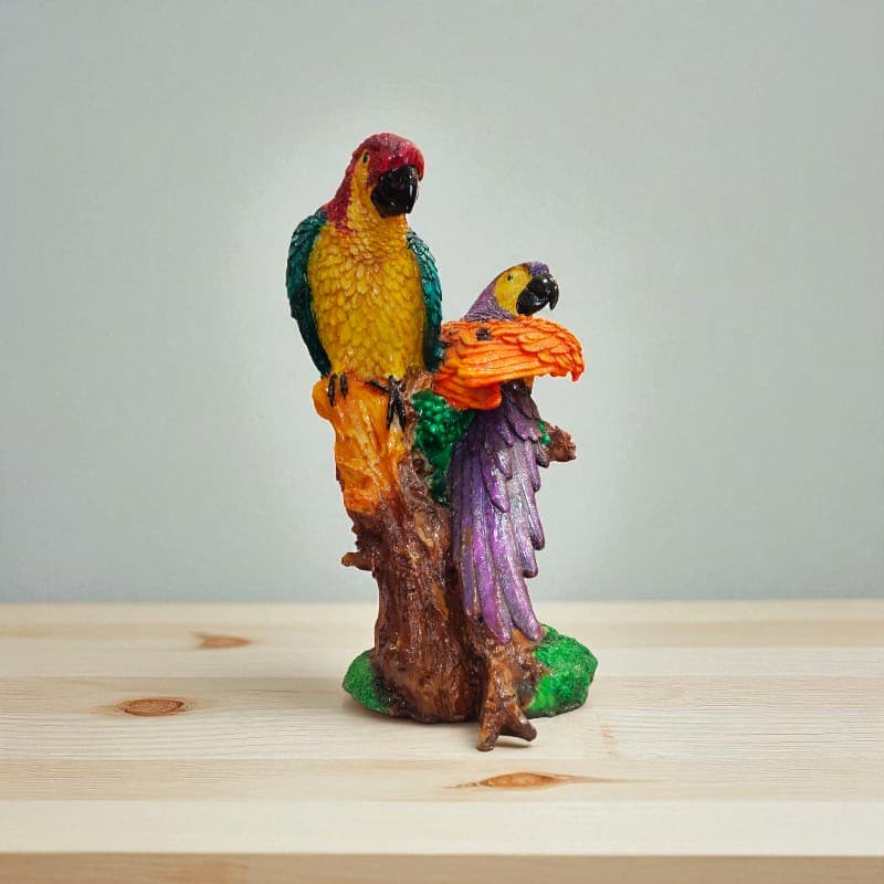 Colorful parrot figurines on a wooden base with a plain background