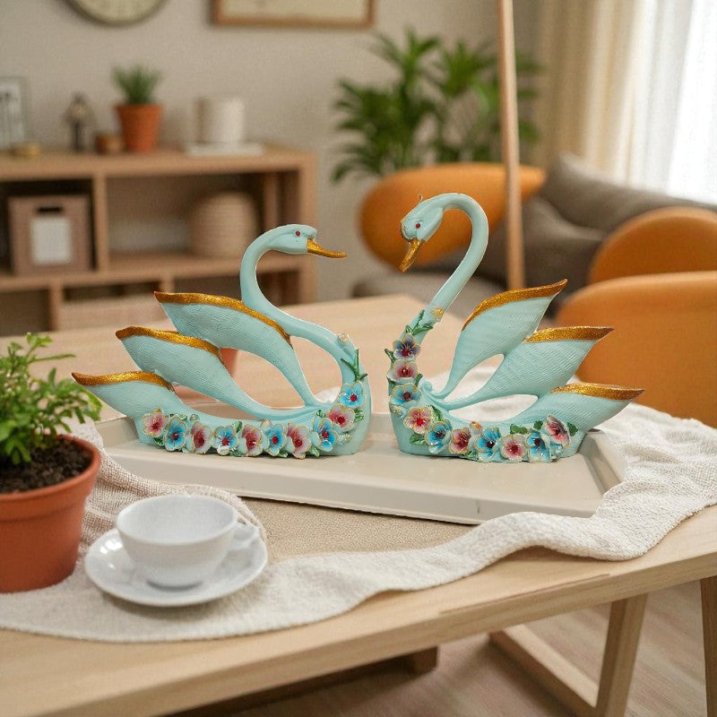 Decorative swan statues on a table with a cozy living room background