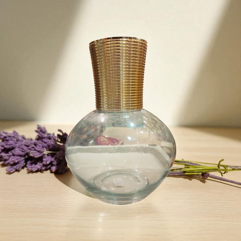 Glass diffuser with wicker top on a wooden surface with lavender and greenery
