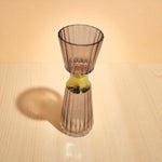 Glass vase with ribbed design on a wooden surface