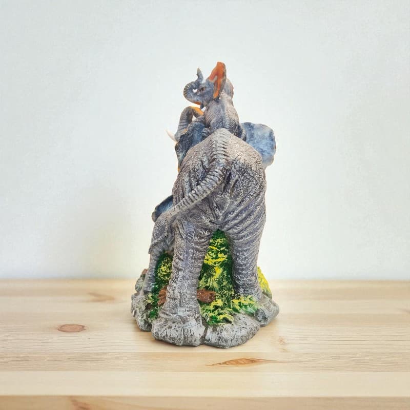 Decorative elephant figurine on a wooden surface with a white background