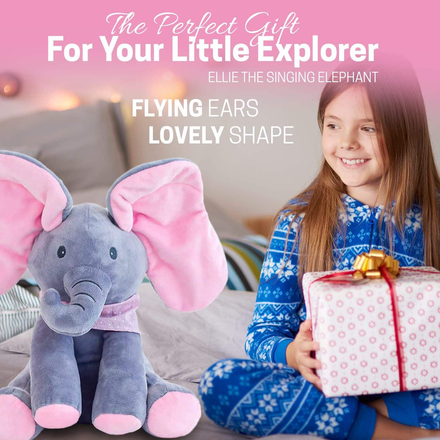 Plush elephant toy with pink flying ears next to a child holding a gift, on a pink background.