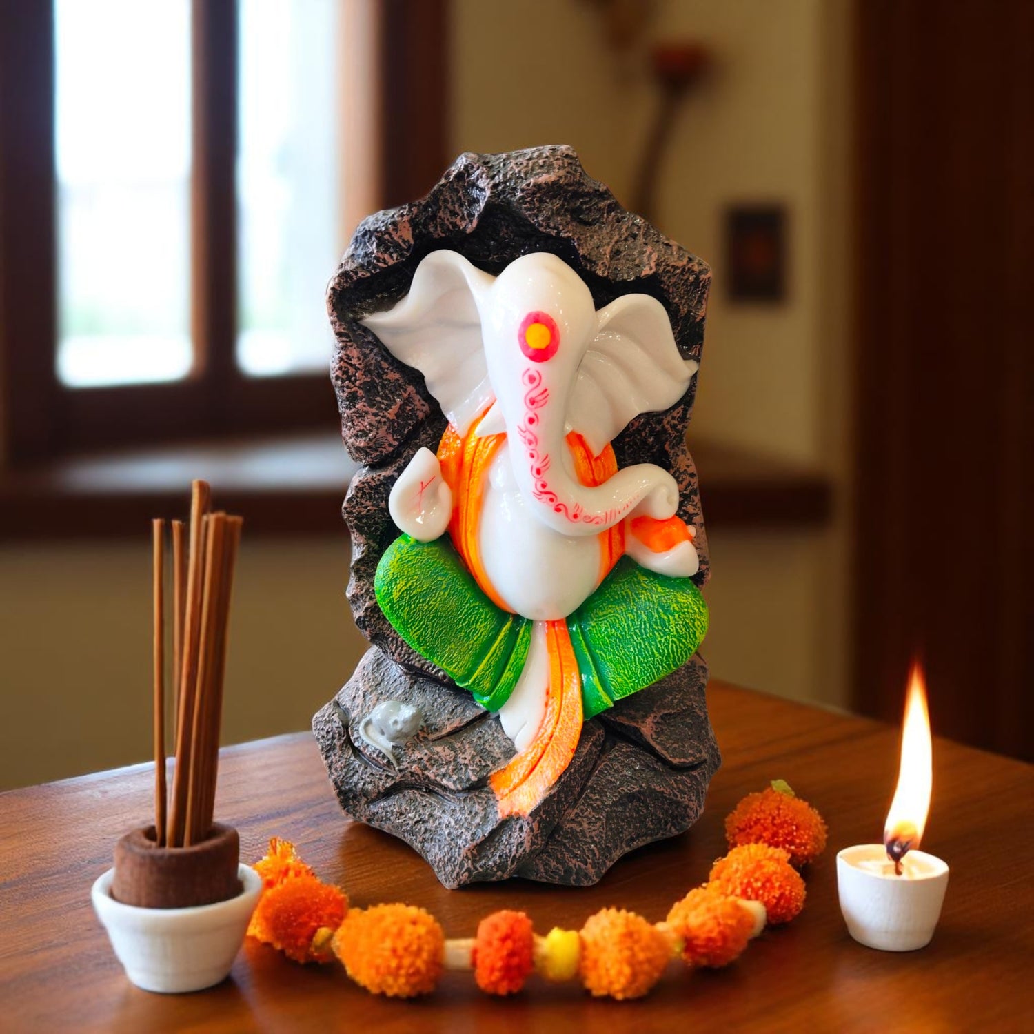 Front view of Ganpati murti with green dhoti and orange stole for home décor
