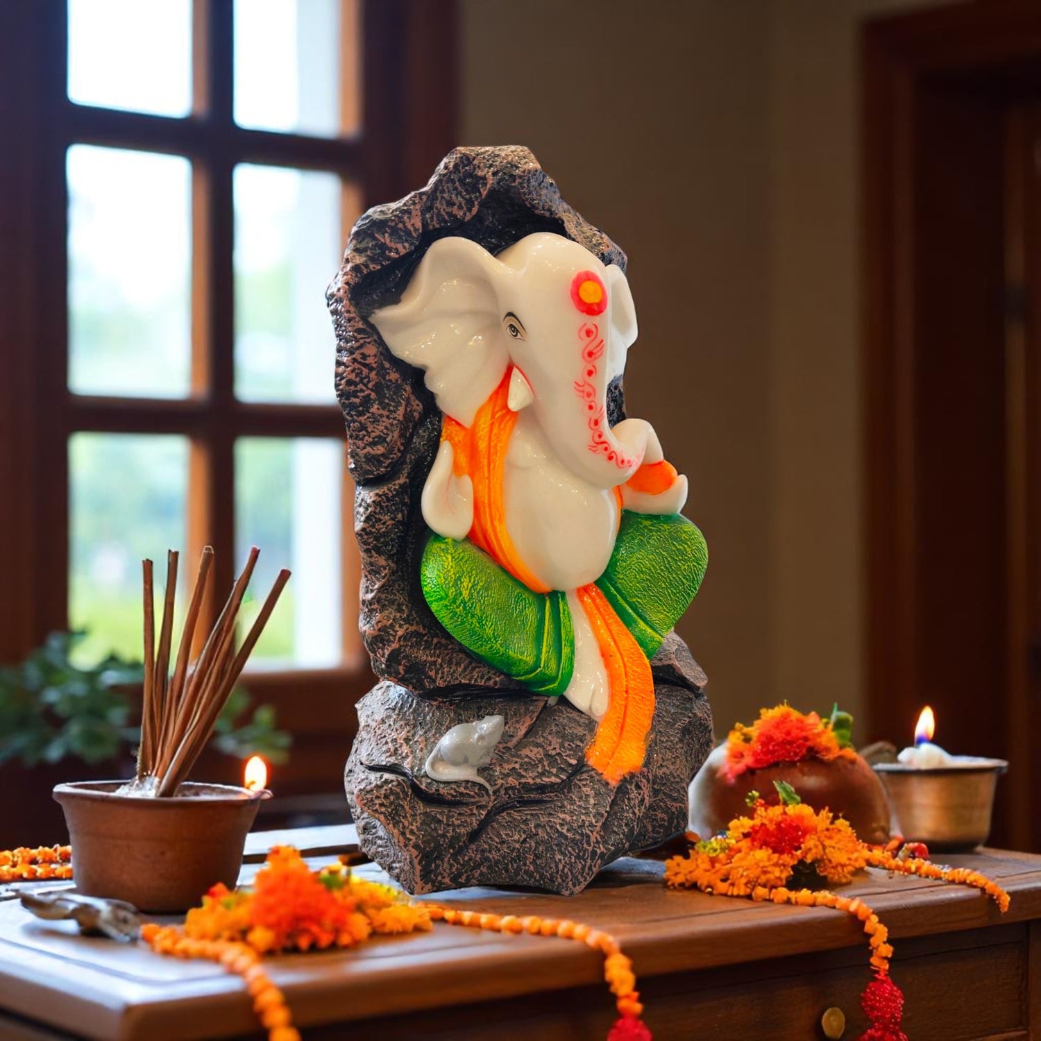 Side view of colorful Ganesha idol seated in rocky cave background