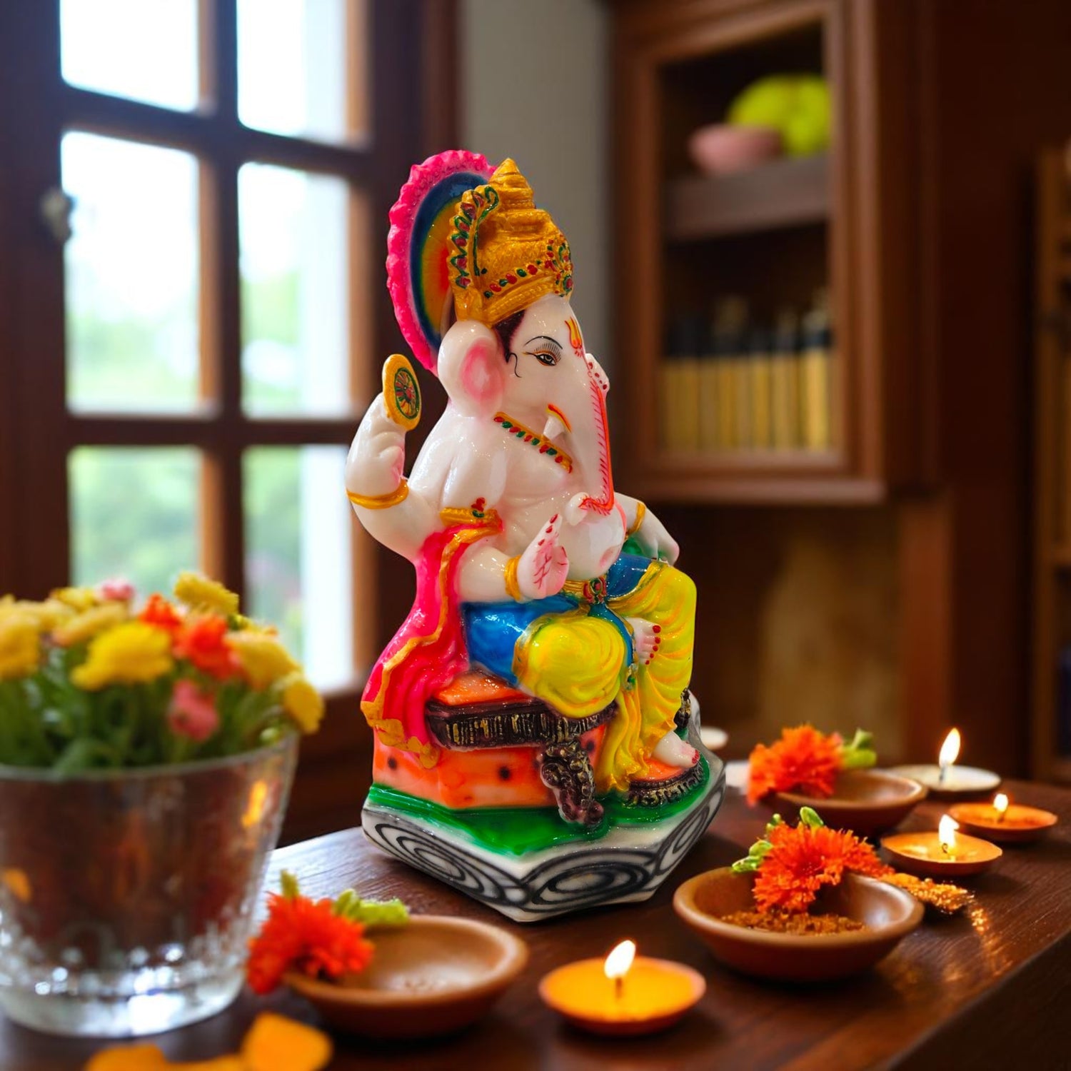 Side view of colorful Ganpati idol sitting in blessing pose with diya decor