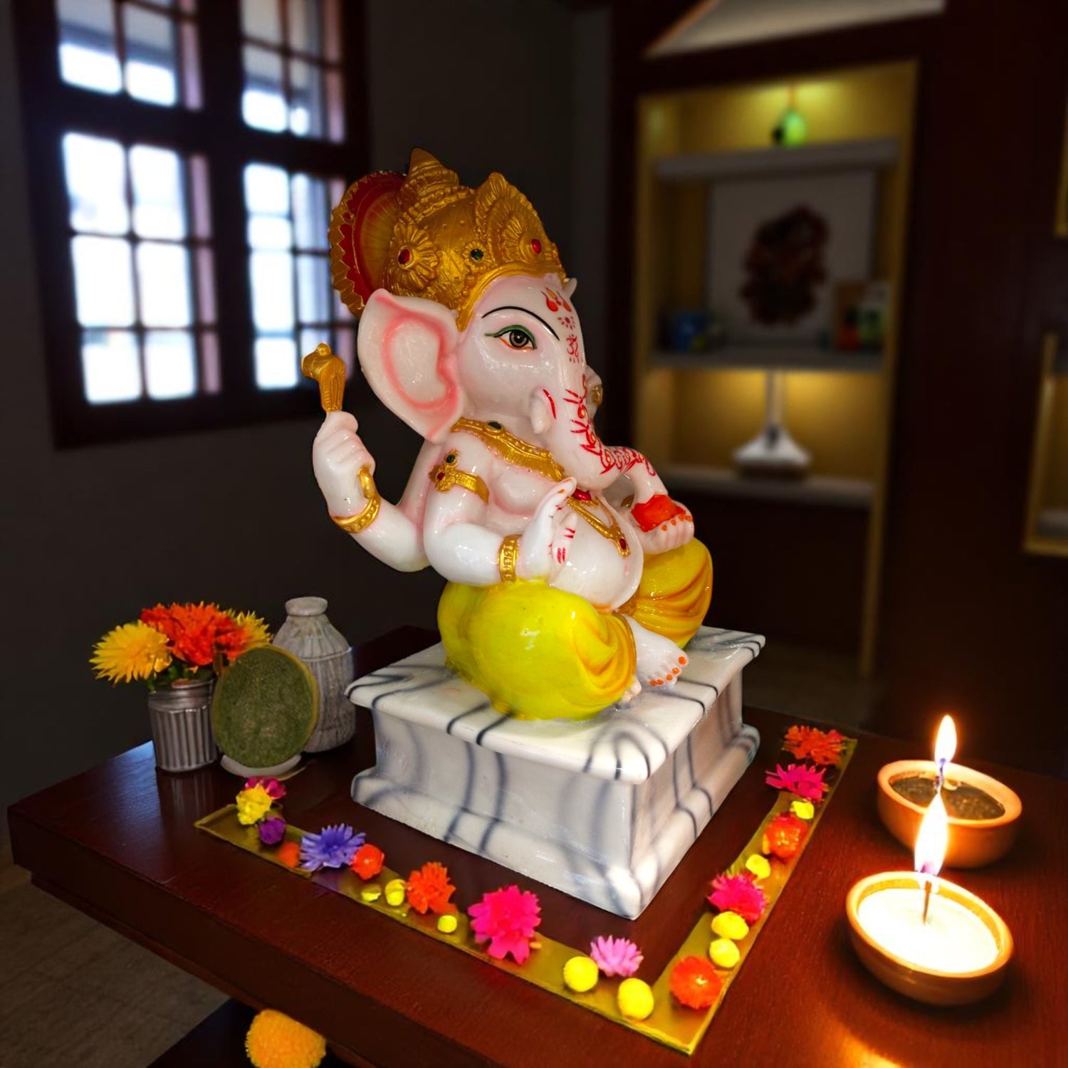 Side view of yellow dhoti ganpati idol in pooja setup