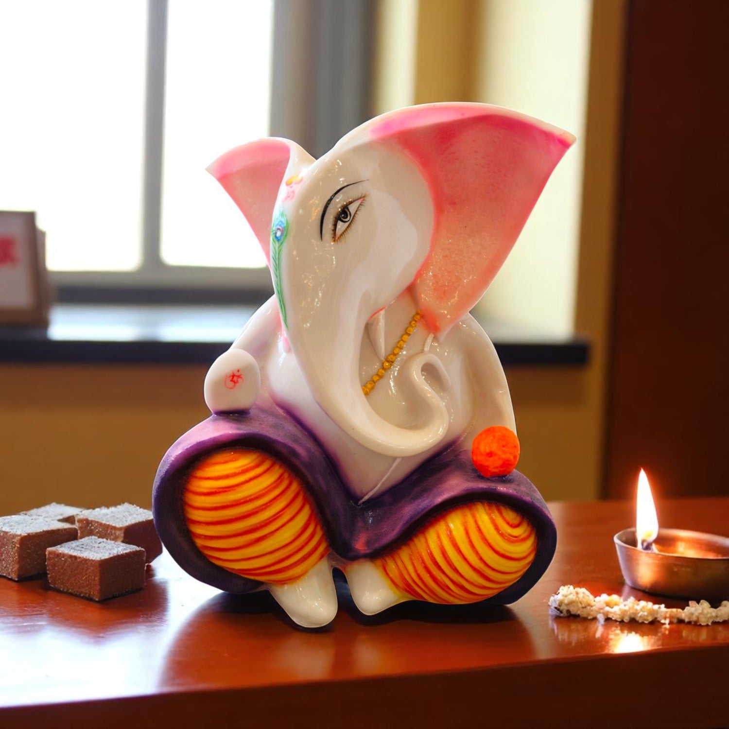  Front angle of pink-eared Ganesha idol with peacock tilak and orange modak