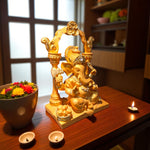 Side angle of Ganpati idol seated under temple-style arch with diyas and flowers