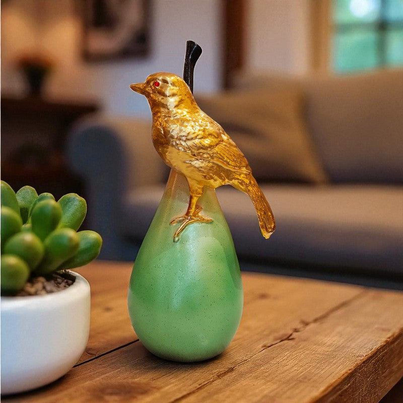 Decorative bird figurine on a green base with a blurred indoor setting