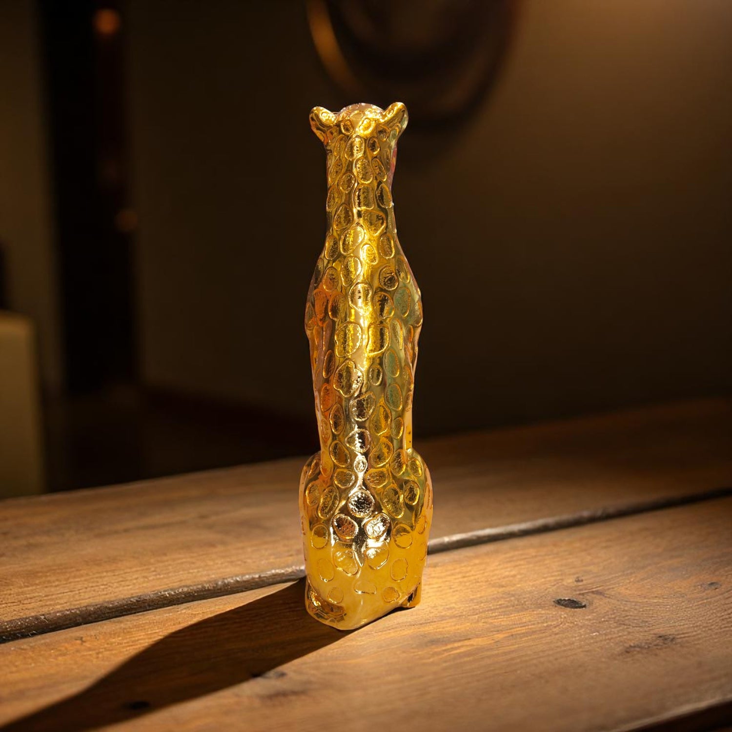 Golden panther decor piece on wooden table with black background