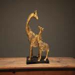 Front view of golden giraffe mother and baby sculpture with emotional bond