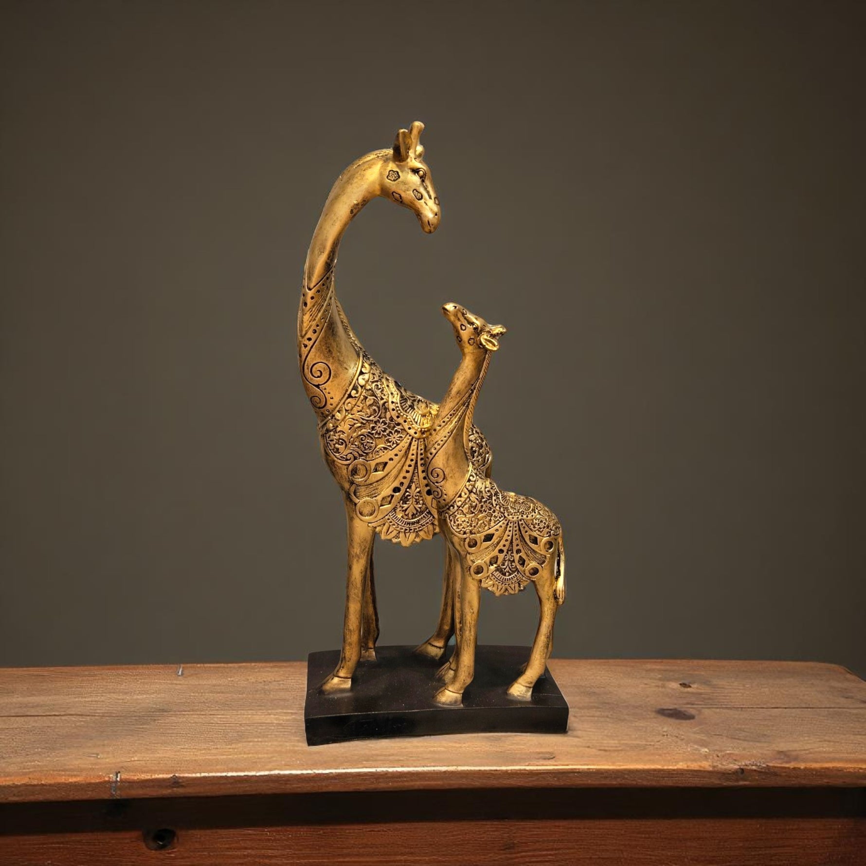 Front view of golden giraffe mother and baby sculpture with emotional bond