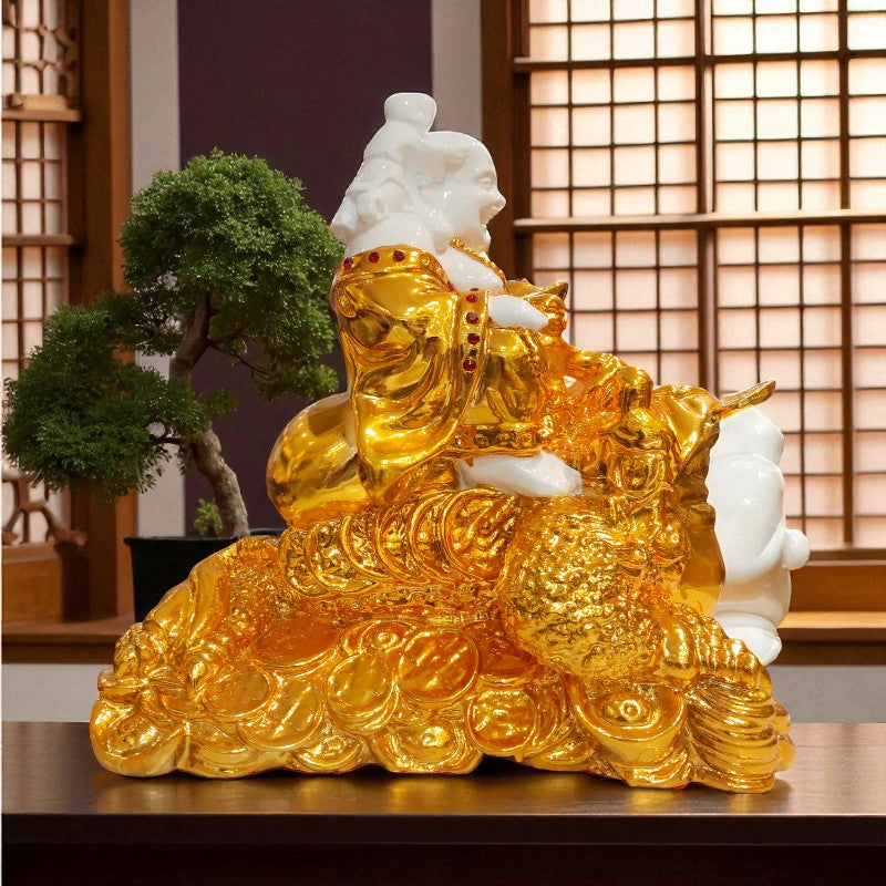 Gold and white statue of a seated figure on coins with a blurred indoor background