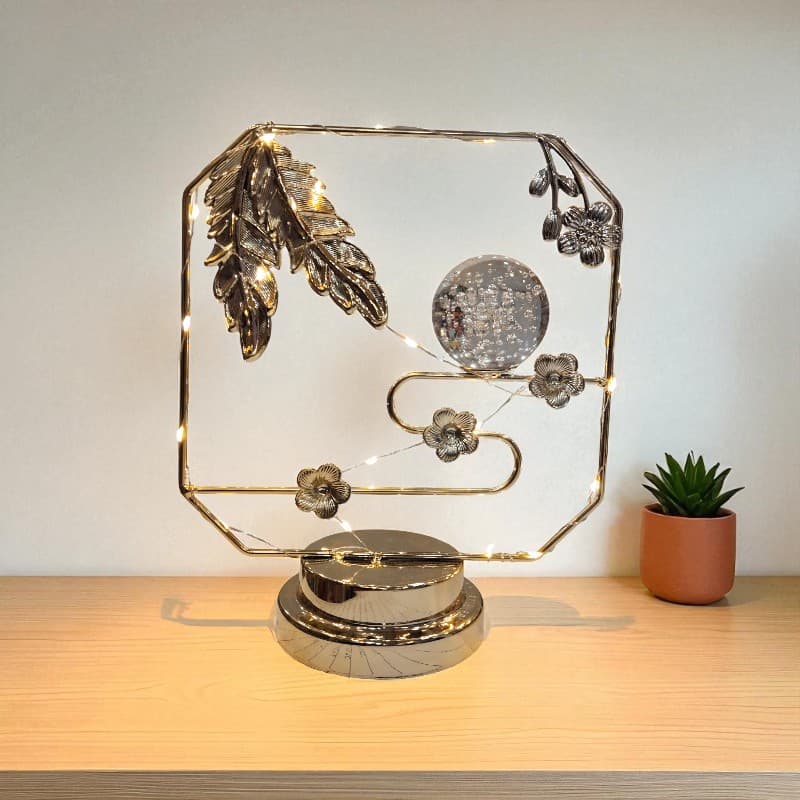 Decorative metal sculpture with lights on a wooden surface