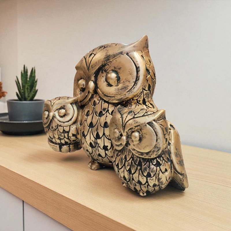 Decorative owl figurine on a wooden surface with a blurred background