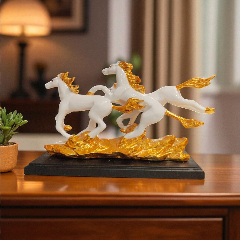Decorative sculpture of three white horses with gold manes on a black base, placed on a wooden surface.