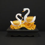  Side view of decorative swan family idol on golden wave base