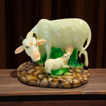 Front view of cow and calf resin idol on green base