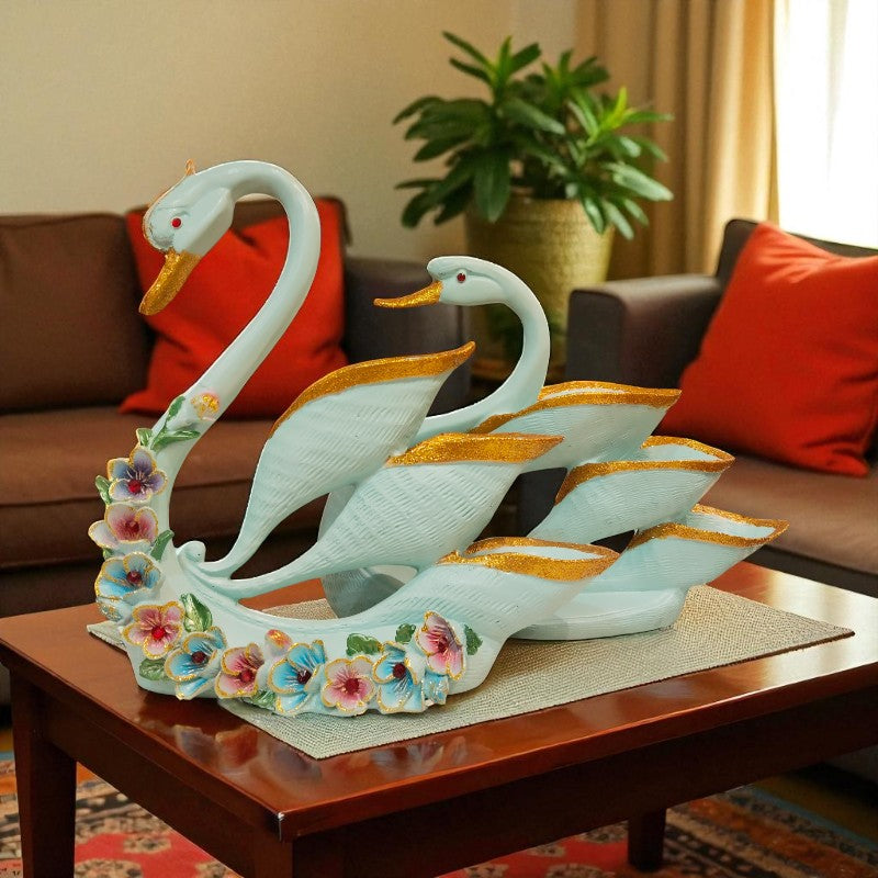 Decorative sculpture of two swans on a coffee table with a living room background