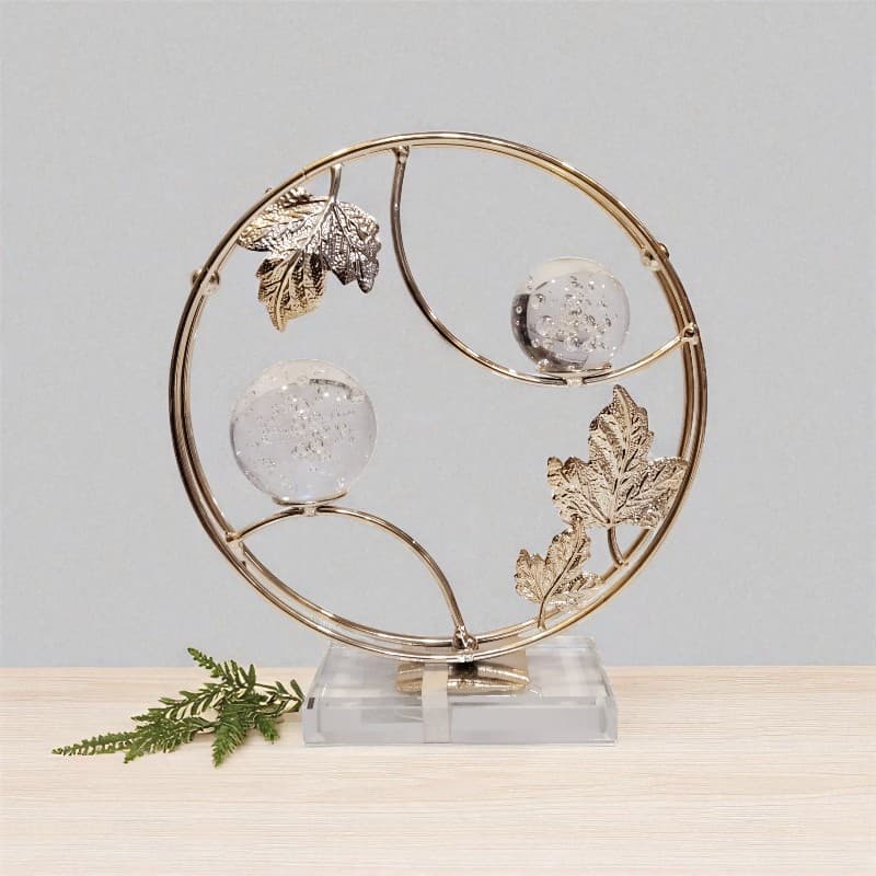 Decorative piece with gold leaf design and crystal balls on a light gray background