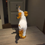 Rear view of white elephant showpiece with golden details on ears and feet