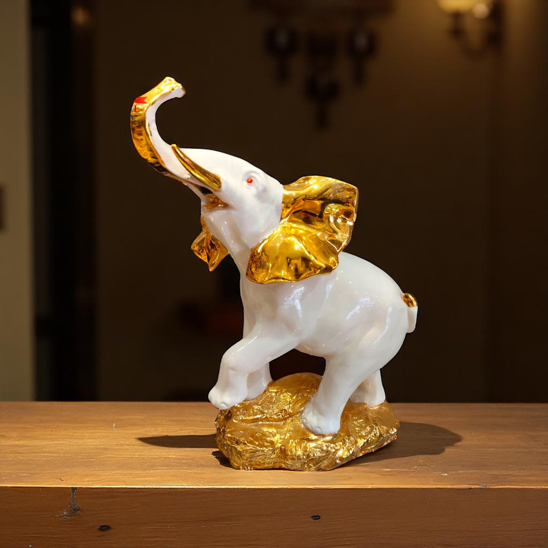 Front view of white elephant idol with trunk up and golden ears