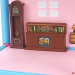 Toy bookshelf with clock against a pink wall