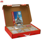 Open box containing card games with a prominent Eiffel Tower design on the cover.