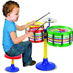 Child playing with a colorful toy drum set on a white background