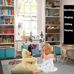 Child playing with teddy bear in a room with bookshelves and toys.