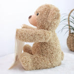 Plush teddy bear sitting on a white surface with a light background