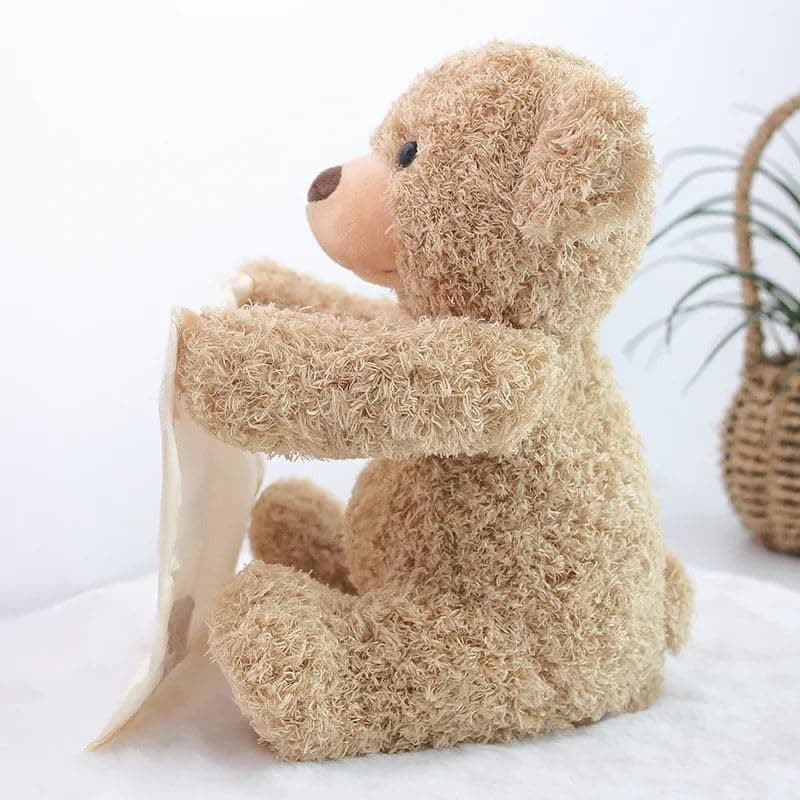 Plush teddy bear sitting on a white surface with a light background