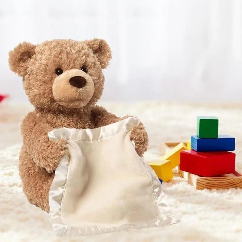 Teddy bear holding a white pillow with colorful blocks in the background